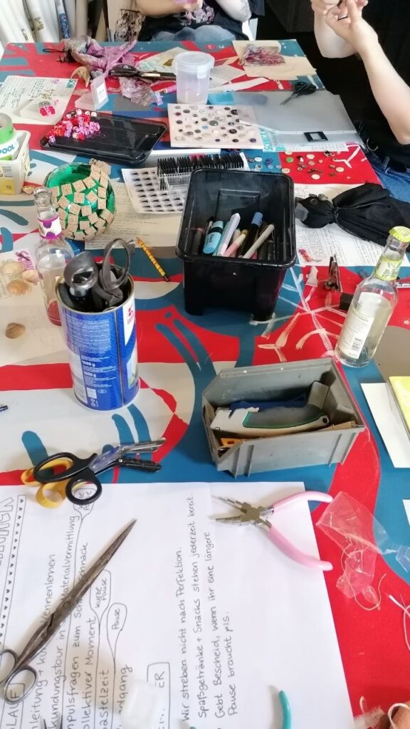 Auf einem Tisch liegen wild verteilt Bastelmaterialien wie Scheren, Stifte und Zangen.
